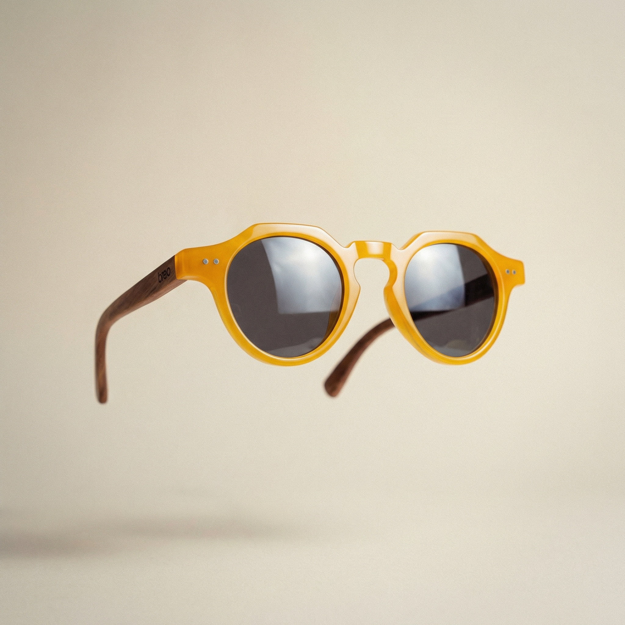 Yellow sunglasses with reflective lenses on a beige background
