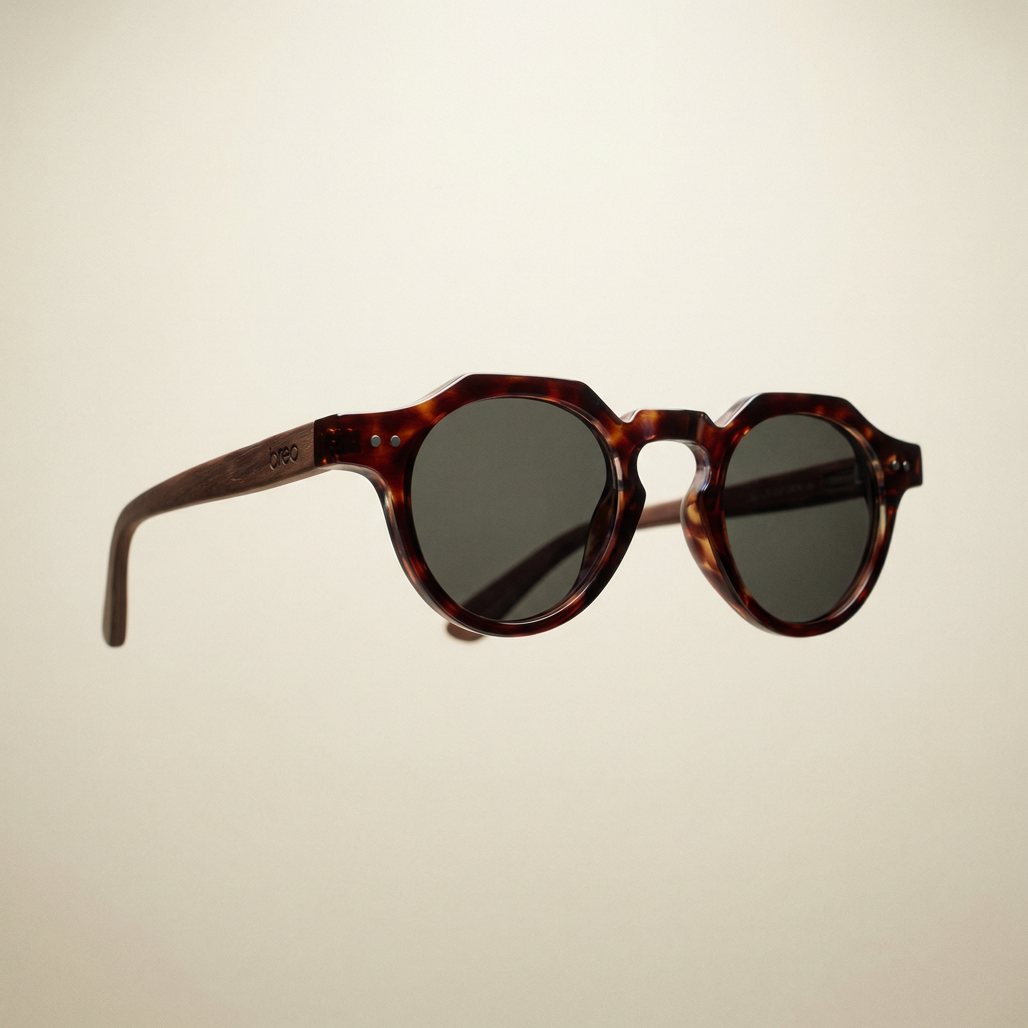 Sunglasses with tortoiseshell frame and dark lenses on a beige background